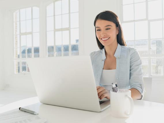 Uśmiechnięta kobieta przed laptopem